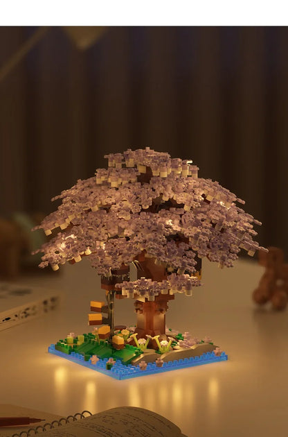 Lighted LEGO model of a cherry blossom tree on a dark background