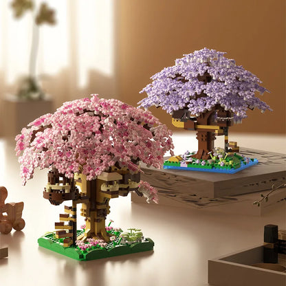 Two cherry blossom tree models made from building blocks on a table.