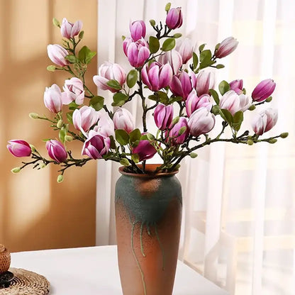 Pink and white flowers in a decorative vase against a neutral background