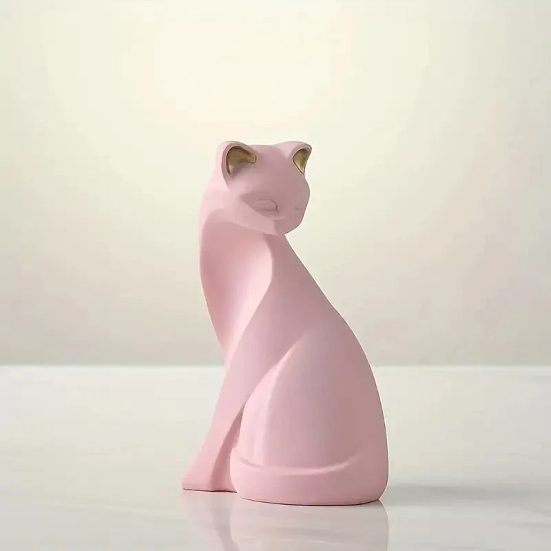 Pink cat-shaped sculpture on a white surface with a light pink background