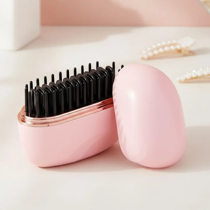 Pink hairbrush with black bristles in a matching case on a light background