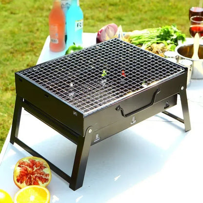 Portable grill on a table with food and drinks in an outdoor setting