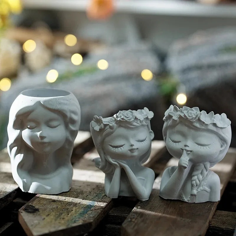 Three small ceramic figurines with facial features on a wooden surface.