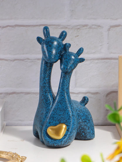 Blue ceramic giraffe figurine with a gold heart on a white surface.