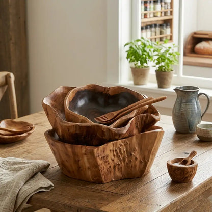 Set of wooden bowls on a wooden table with a window and plants in the background