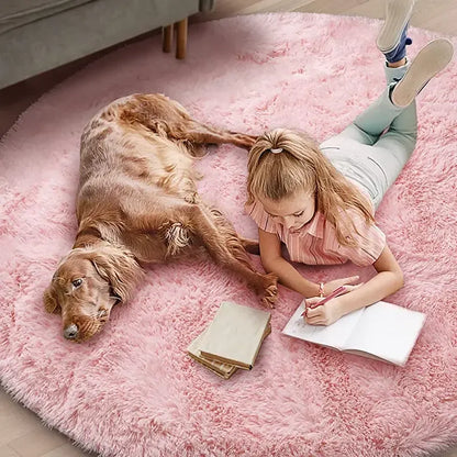 Girl lying on a pink rug with a dog, reading a book.