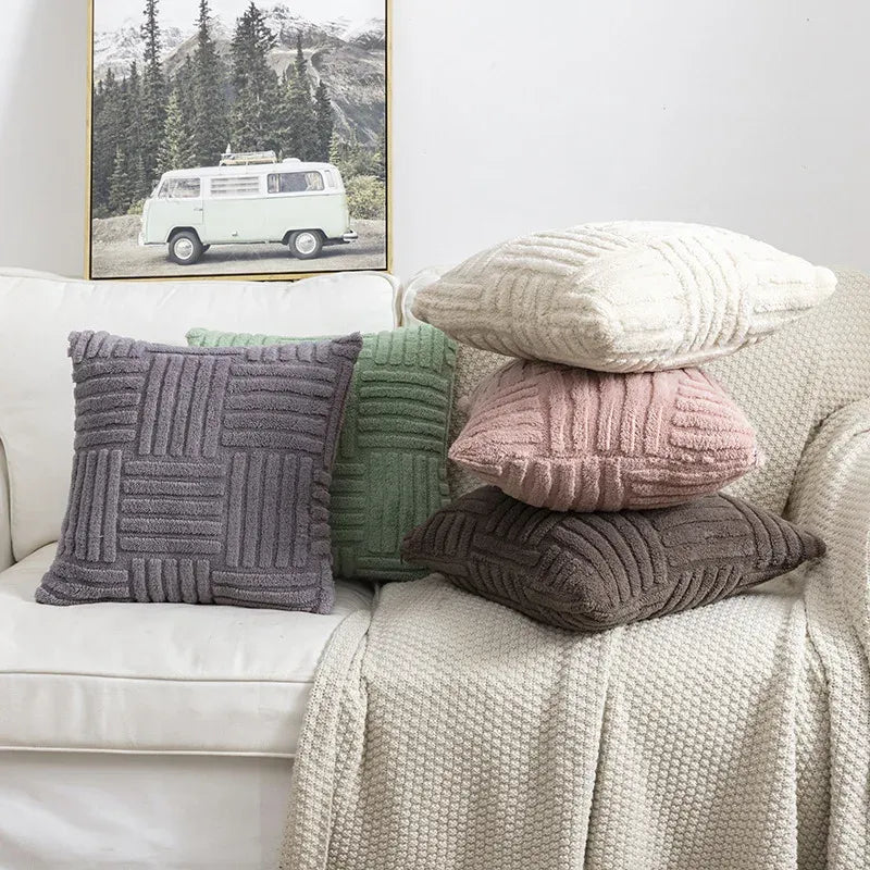 Stack of textured pillows on a sofa with a framed picture of a van in the background.