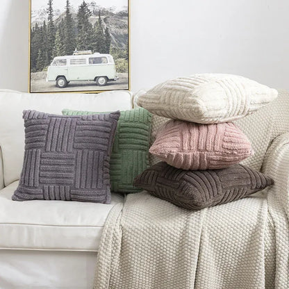 Stack of textured pillows on a sofa with a framed picture of a van in the background.