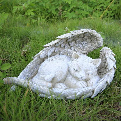 Statue of a cat with angel wings on grass