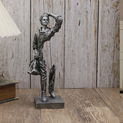 Statue of a dancer on a wooden floor with a wooden panel wall in the background