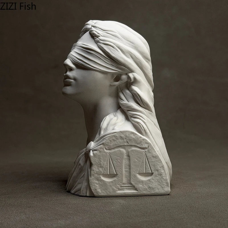 Statue of a woman with a blindfold and scales on a dark background