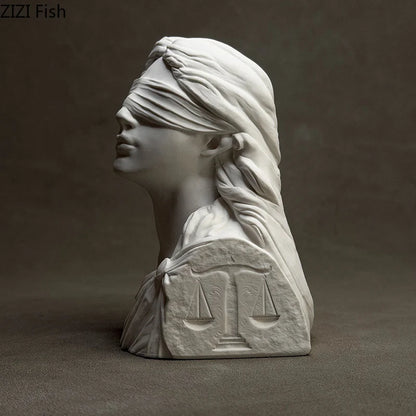 Statue of a woman with a blindfold and scales on a dark background
