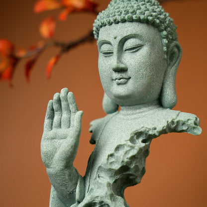 Stone statue of a Buddha with a blurred autumn tree background