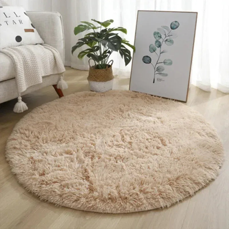 Round beige rug in a living room with a couch, plant, and artwork.