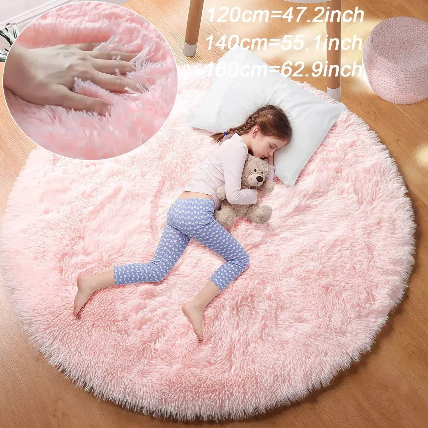 Pink fluffy rug with a child lying on it, holding a teddy bear, with measurements inset.