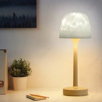 Table lamp emitting a warm glow in a room with a plant and books.