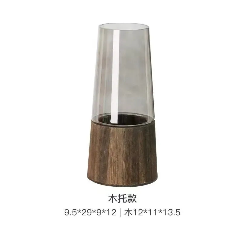 Tall cylindrical vase with wooden base and transparent glass top on a white background