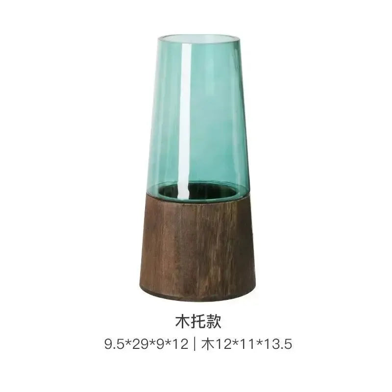 Tall glass vase with wooden base on a white background