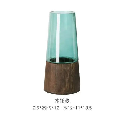 Tall glass vase with wooden base on a white background