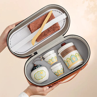 Tea set in a carrying case held by a hand on a beige background