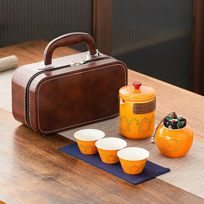 Tea set with orange teacups and teapot on a wooden table
