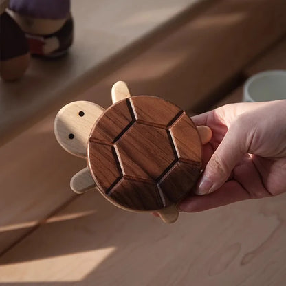 Wooden turtle puzzle held by a hand on a wooden surface