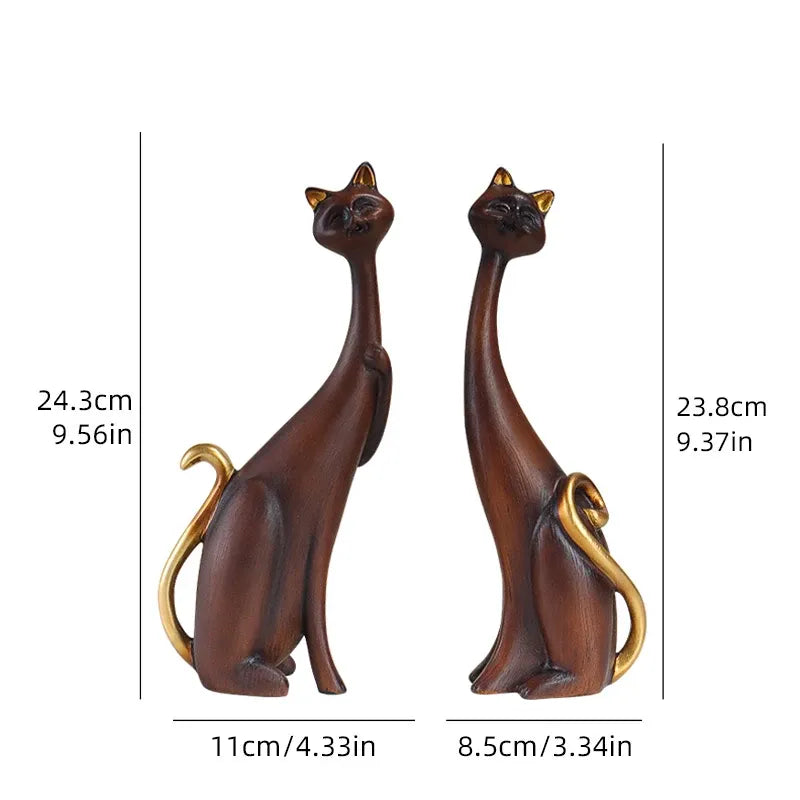 Two cat-shaped figurines with measurements on a white background