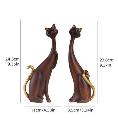 Two cat-shaped figurines with measurements on a white background