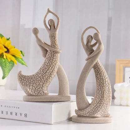 Two ceramic figures of people in a dance pose on books with a blurred background
