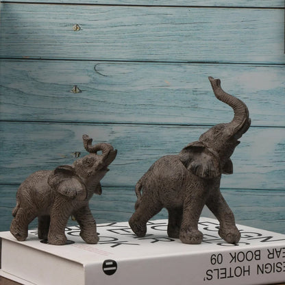 Two elephant figurines on a box with a blue wooden background