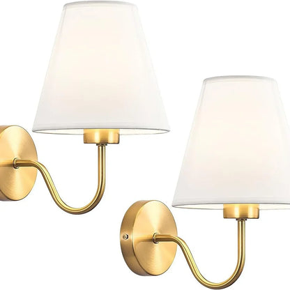 Two gold wall sconces with white lampshades on a white background