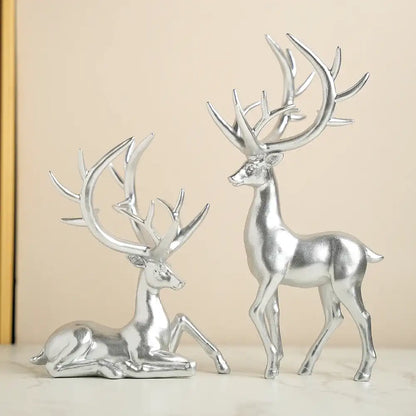 Two silver deer figurines on a beige background