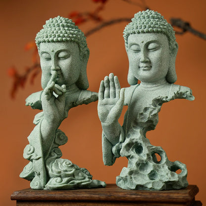 Two stone Buddha statues on a wooden base with an orange background