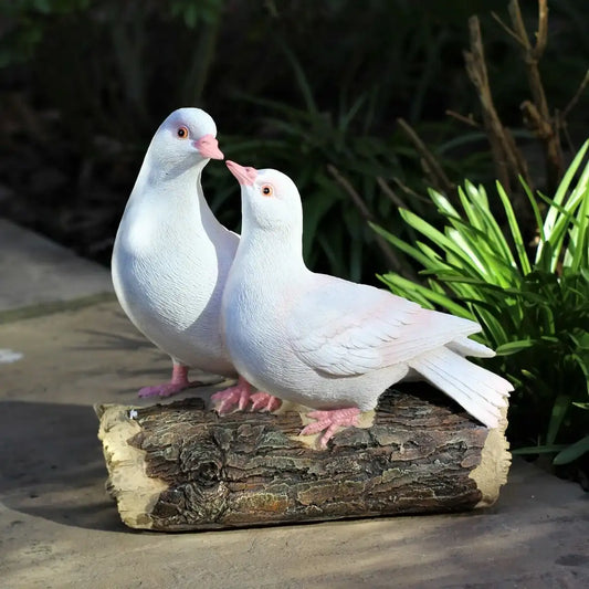 Two white doves standing on a log with greenery in the background