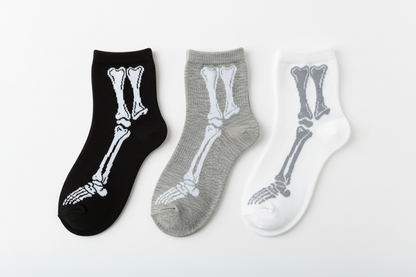 Flat lay of unisex ankle bone socks in all three colors black grey and white showing skeleton bone print on each