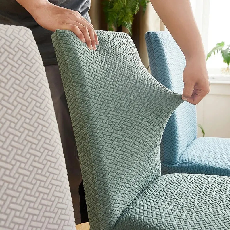 Person adjusting a textured green fabric cover on a chair.