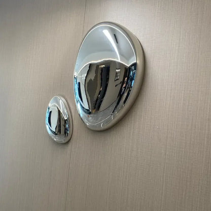 Two metallic Modern Water Drop Wall Decor on a beige textured surface