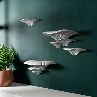 White Mushroom Wall Shelf resembling mushrooms on a dark green wall with a plant on a table.