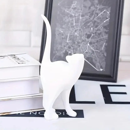 White cat figurine on a surface with a map in the background