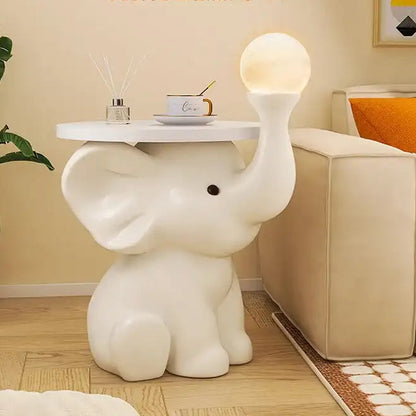 White elephant-shaped side table with a lamp in a room setting.