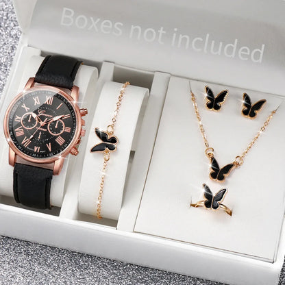 Watch and butterfly-themed jewelry set on a gray surface