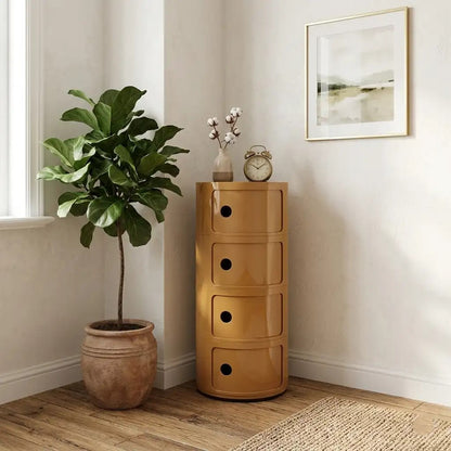 Wooden chest of drawers next to a potted plant in a room with a clock and decor.