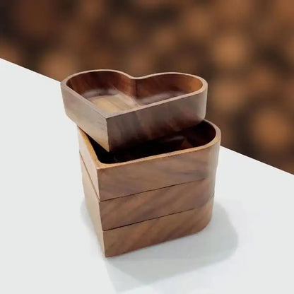Wooden heart-shaped container on a white surface with a blurred brown background