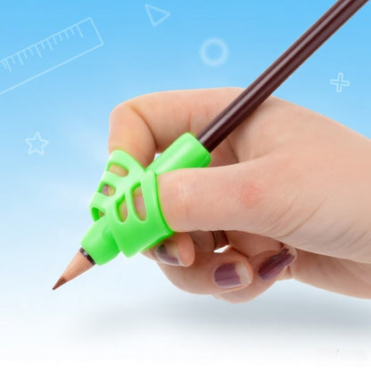 Hand holding a pencil with a green grip trainer against a light blue background