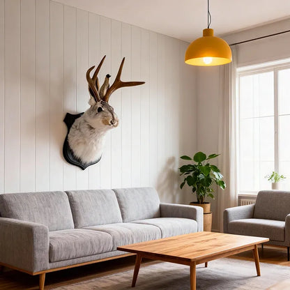 Living room with a gray sofa, a wooden coffee table, and a deer head mounted on the wall.
