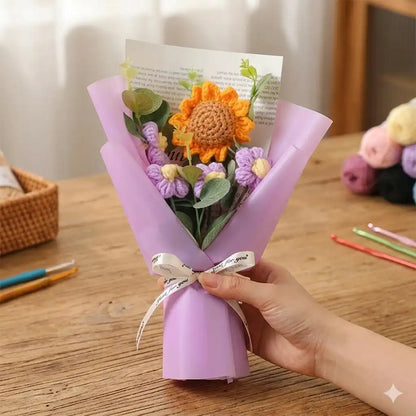 Hand holding a bouquet wrapped in purple paper on a wooden table.