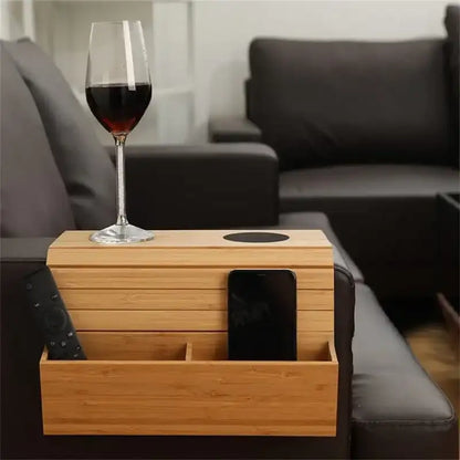 Wooden side table with compartments holding a glass of red wine and a phone, placed on a sofa.