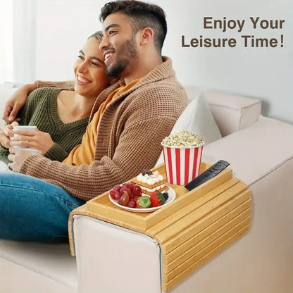 Couple on a couch with a wooden tray holding snacks and a remote, with text 'Enjoy Your Leisure Time!'.