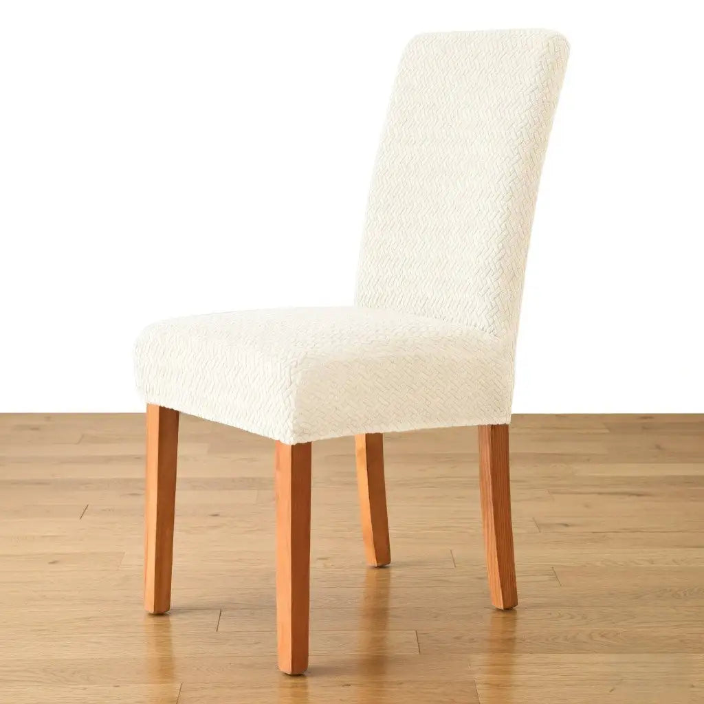 White upholstered chair with wooden legs on a wooden floor