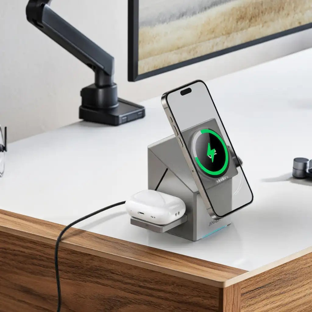 Desk setup with a smartphone on a charging stand displaying a charging icon, next to a pair of wireless earbuds.